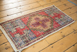 Decorative distressed Oushak rug with prominent diamond medallion in cochineal red and apricot.