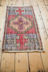 Vintage Distressed Oushak rug showing worn red, apricot, and blue geometric motifs.