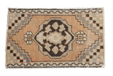 Distressed Oushak rug mat, center medallion, checker spandrels. Sandalwood, charcoal, ivory. 1'10
