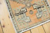 Distressed tangerine orange Oushak rug corner, showcasing geometric patterns and even wear.