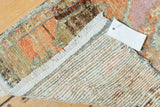 Distressed vintage Oushak rug corner shows terracotta, bronze pile with wear and woven foundation.
