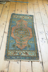 Angled view of distressed Oushak runner in terracotta, slate blue, mint, showcasing low pile.