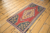 Distressed cochineal red field, dark geometric border, and intact side selvage.