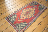 Distressed Oushak runner's right section with geometric apricot medallion and cochineal red field.
