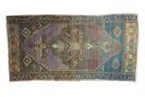 Distressed vintage Oushak rug runner with central quatrefoil medallion in indigo, lavender, and sand.