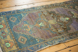 Oushak runner's distressed, abrashed pile with dusty blue, rich lavender, and bright mint.