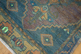 Angled detail of the vintage distressed Oushak rug showing texture, geometric motifs, dusty indigo, and sand tones.