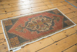 Distressed vintage Oushak rug corner with stepped charcoal spandrel, brick red, and ivory fringe.