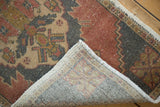 Distressed vintage Oushak rug corner with hand-knotted foundation, fringe, and worn pile.