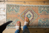 Distressed vintage Oushak rug mat, stepped medallion and splayed floral motif.