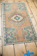 Apricot and slate blue-green tones with distressed texture on vintage Oushak rug edge.