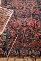 Thick pile Lilihan runner with dark blush field, navy blue floral vinery, and tattered edge.