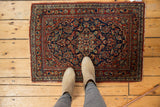Vintage Persian Kashan rug with detailed quatrefoil medallion, navy, red scrolling floral field, and even wear.