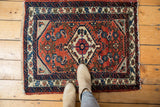Corner of vintage Engelas rug, featuring brick red Herati field and navy blue patterned border.