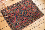 Tattered end fringe and intricate navy, raspberry borders on a vintage Sarouk rug.