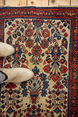 Vintage Sarouk rug detail: low pile, ivory ground, cherry red, sky blue tree-of-life pattern.