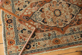 Dusty rust, ivory, navy vine and barber pole patterns on antique Tabriz rug border.