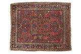 Vintage German Sarouk rug, cherry red field, scattered blue floral bouquets, geometric border.