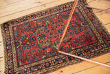 Tattered corner, cherry red field with blue floral motifs and navy border.