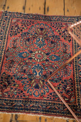 Vintage American Sarouk rug corner with intricate floral bouquets, navy border, light tattered fringe.