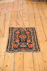 Vintage Borchalou rug corner, navy background, gold and orange palmette motifs, with edge tatter.