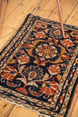 Tattered lower right corner of the vintage Borchalou rug with navy, gold, and red scrolling palmettes.