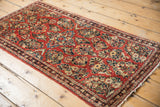 Detailed cherry red floral bouquets and ornate side border on vintage American Sarouk rug.