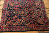 Vintage American Sarouk rug detail: intricate red and beige floral bouquets on a dark navy field.