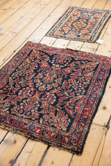 Vintage American Sarouk rug with dark navy ground, red floral branches, and patterned border.