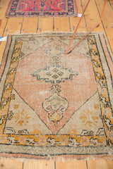 Vintage Oushak rug corner showing dusty peach field, diagonal spandrel, and tattered fringe.