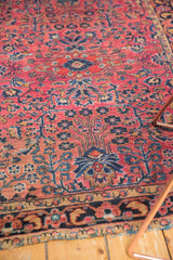 Vintage Sarouk rug detail: navy blue floral tree, dusty raspberry field, worn edge.