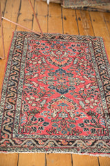 Vintage Dargezine rug corner displays dusty brick floral field, navy border, fringe.