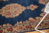 Vintage Kerman rug corner with indigo field, European Rococo spandrel, and rose borders.
