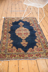 Tattered fringe and vibrant cochineal red rose motifs along the Kerman rug border.