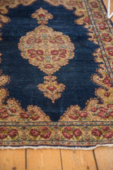 Vintage Kerman rug's lower border with cochineal red rose motifs and fringe.