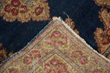Hand knotted vintage Kerman rug corner with tattered side, rose border, and indigo field.