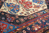 Hand-knotted pile of a Malayer rug, featuring a navy blue border and ivory geometric field.