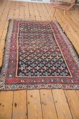Antique Kurdish rug end with tattered finish, red-blue geometric border, medallion field.