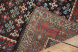 Folded antique Kurdish rug revealing geometric medallions, gentle pile wear, and its hand-knotted foundation.