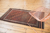 Hand-knotted Antique Belouch runner's allover germinating tree motifs in chestnut and charcoal, with mostly even wear.