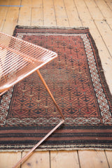 Antique Belouch runner's chestnut and charcoal repeating floral panels, showing tattered end.