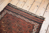 Frayed end of antique Belouch runner, showing geometric panels and germinating flower motifs.
