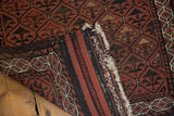 Antique Belouch runner showing chestnut panel pattern, charcoal striped back, and tattered ivory fringe.