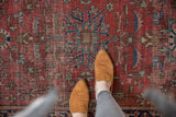 Foot on antique Farahan Sarouk rug, intricate floral vines, dusty red field, foundation wear.