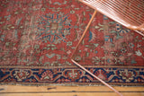 Antique Farahan Sarouk rug's worn dusty cherry field and tattered navy floral border.