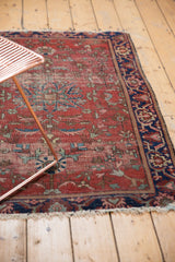 Antique Farahan Sarouk rug corner with visible foundation, hard tattered edge, and navy floral border.