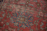 Antique Farahan Sarouk rug's intricate floral medallion, vines, and palmettes with noticeable wear.