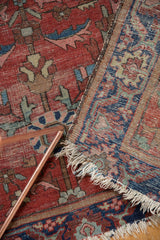 Worn floral pile, exposed hand-knotted foundation, and tattered fringe of an antique Farahan Sarouk rug.
