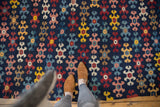 Antique Karabagh Kilim runner, colorful staggered geometric motifs on navy, overhead view with feet.