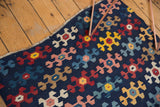 Staggered geometric motifs and alternating colors on an antique Karabagh Kilim, in navy, blush, saffron, and red.